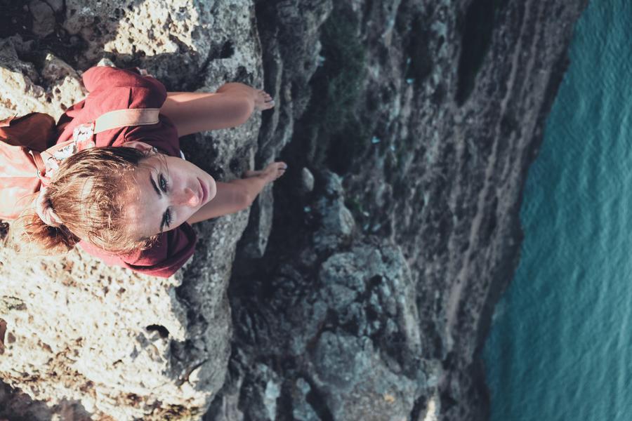 Girl Sitting On The Edge Of A Cliff Water