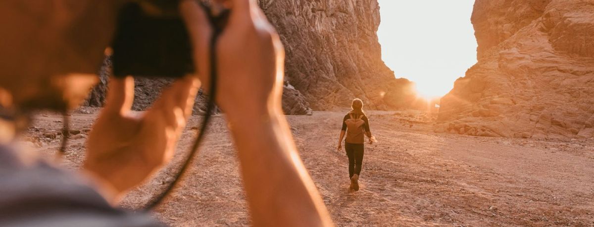 photographer taking a sunset photo with something walking out in the distance
