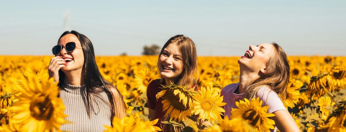 happy laughing women in a sunflower field