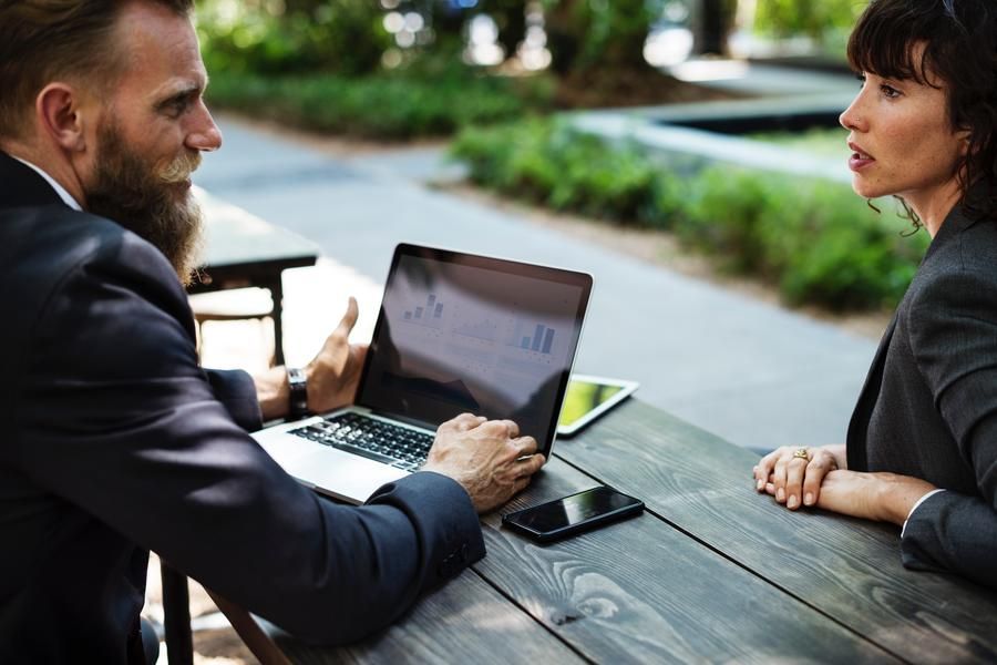 A Man & Woman Talking With A Computer