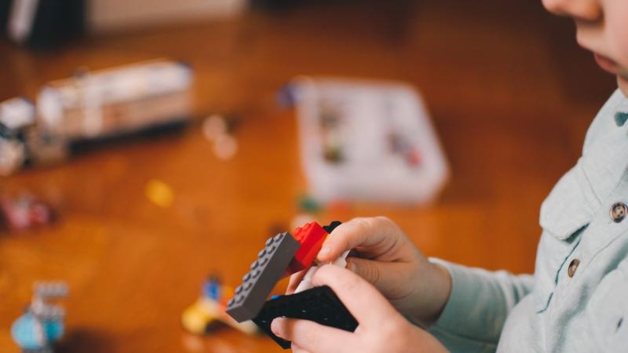 kid building lego blocks