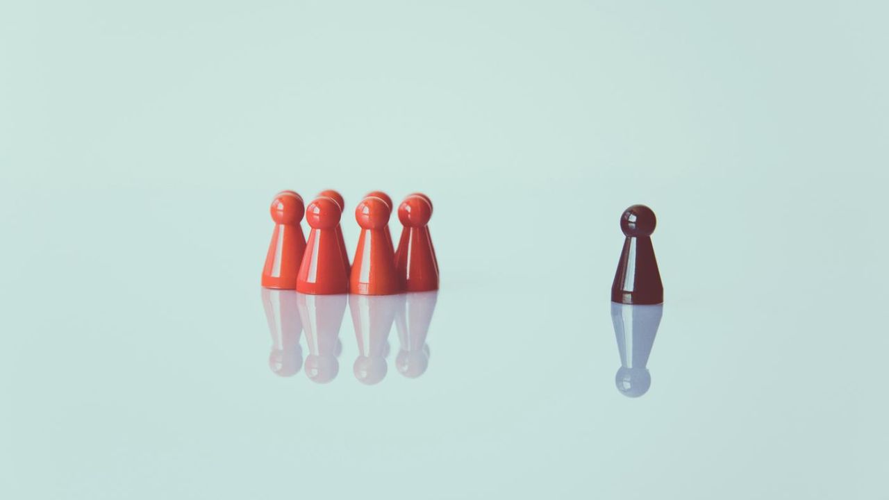 photo of a game pawns on a glass table with a red standout