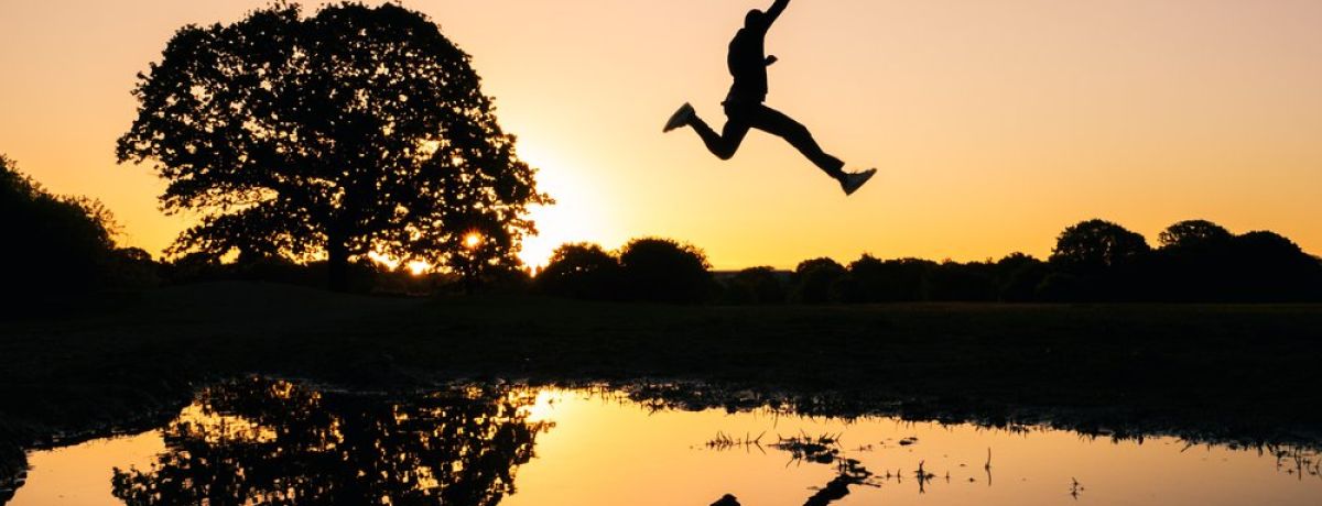 man jumping high across water