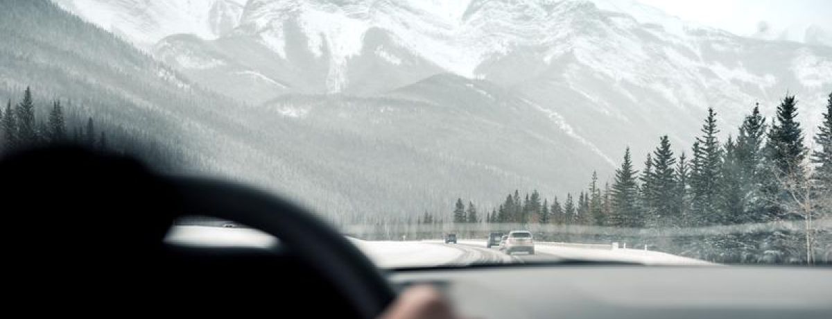 Driving in car toward winter mountain
