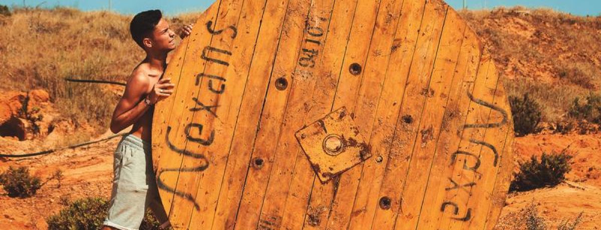 boy pushing large round object