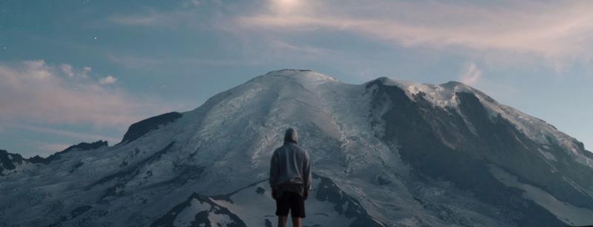 man looking up at mountain