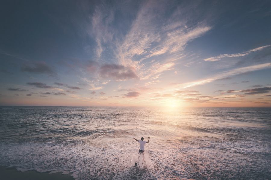 man looking out at the sky and sun