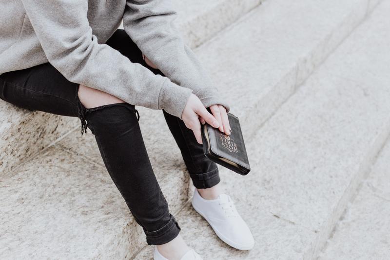 Bible in woman's hand on steps