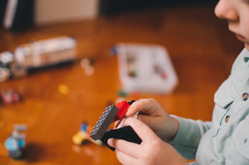 kid building lego blocks