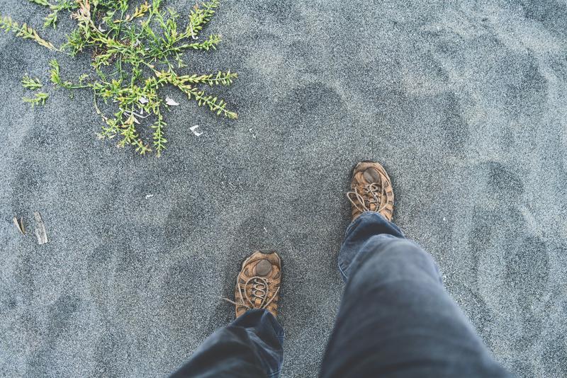 Steps onto sand, feet view