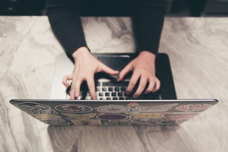 Hands typing on a laptop computer