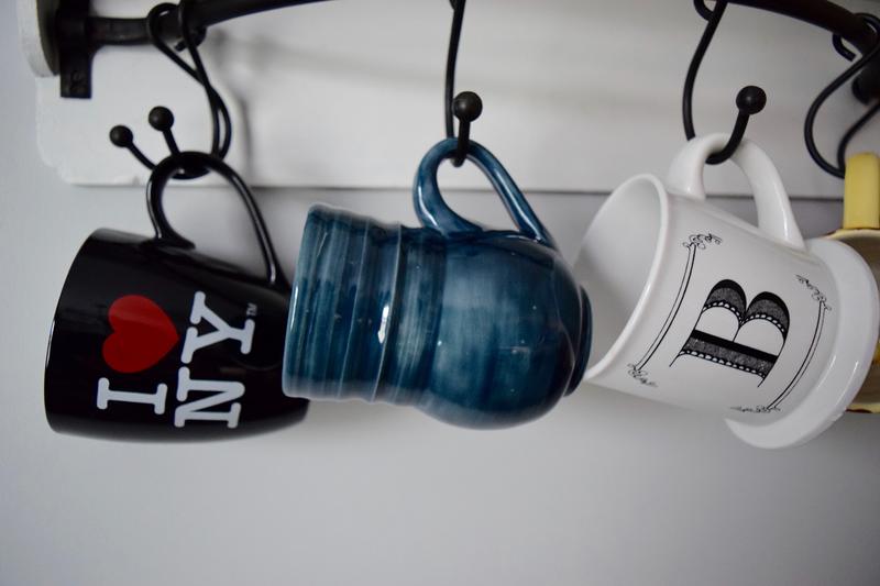 several mugs hanging on the rack