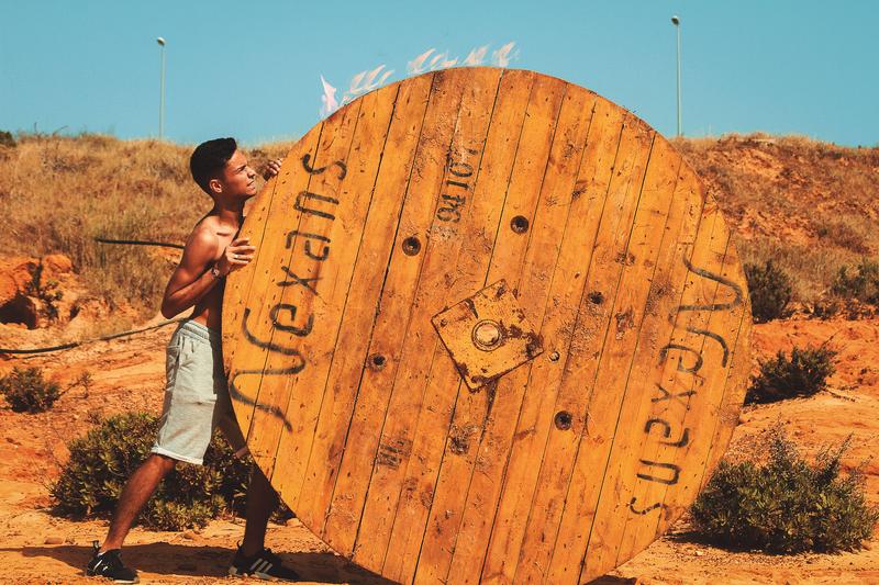 boy pushing large round object
