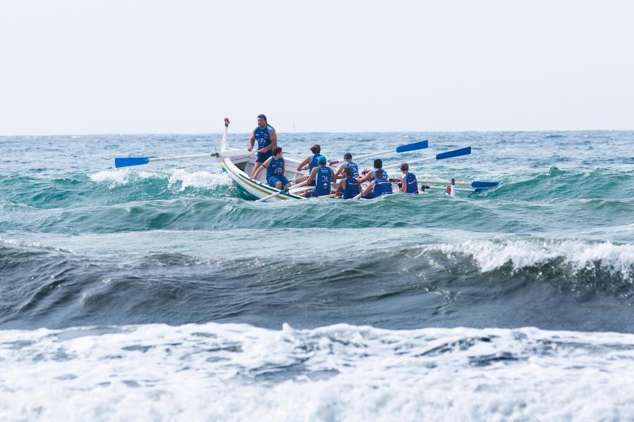 group of people working together to row the boat forward