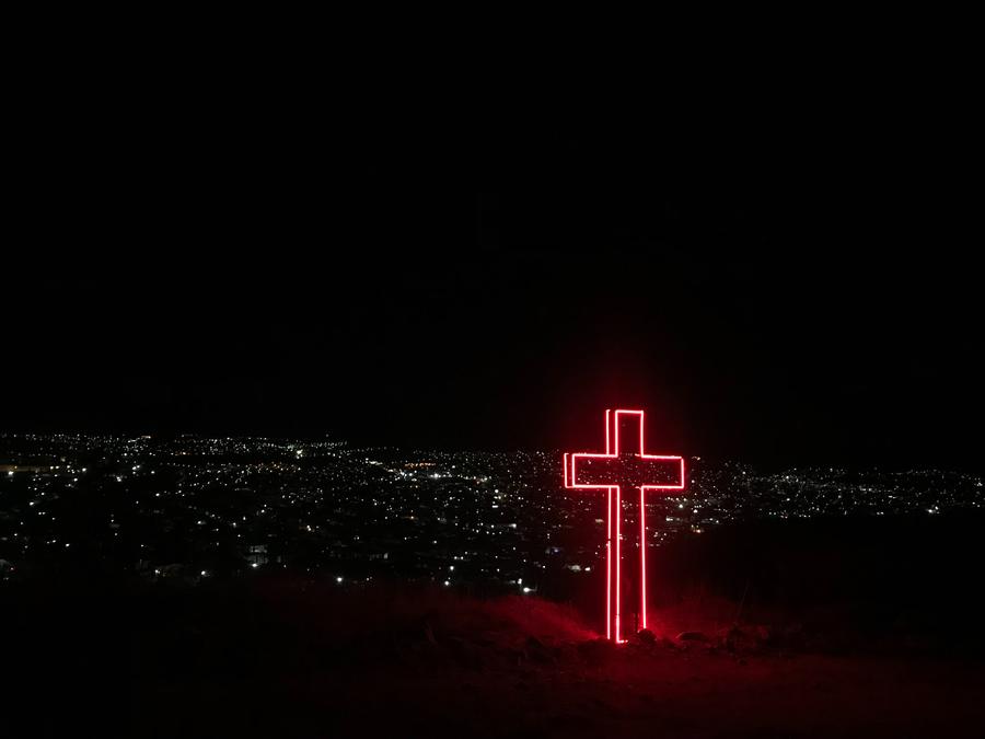 red lit cross on a hill
