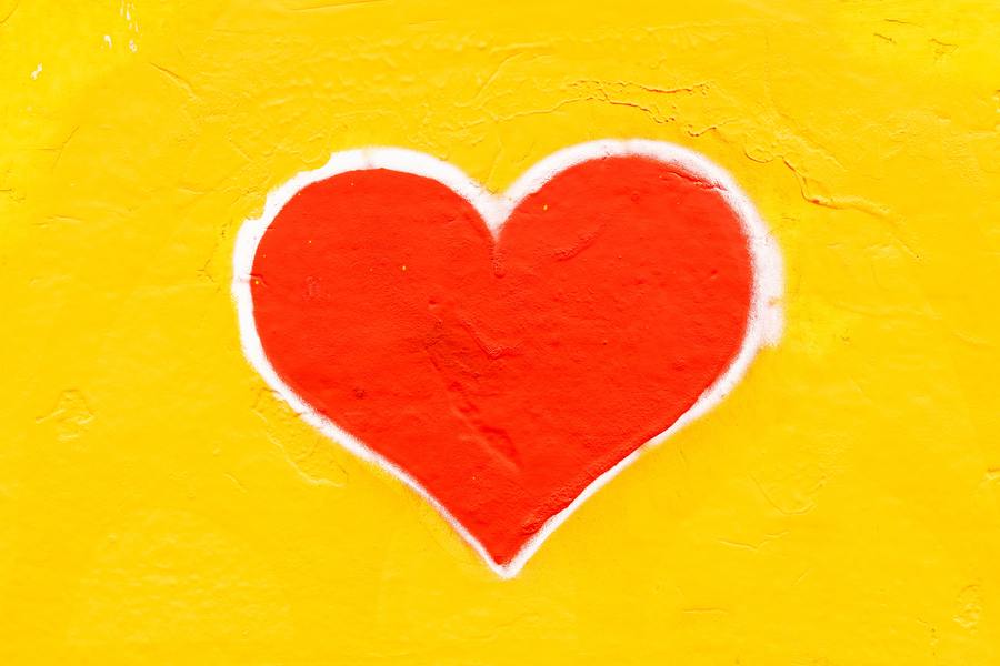 red painted heart on a yellow wall