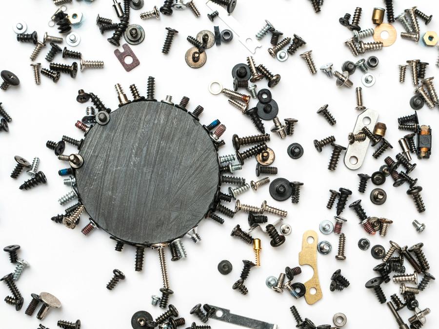 a magnet on a white table with screws around