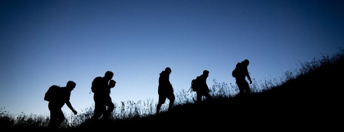Group of people hiking up hill in the dark