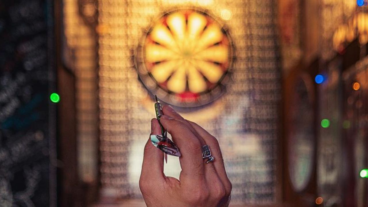 person preparing to throw a dart at the target