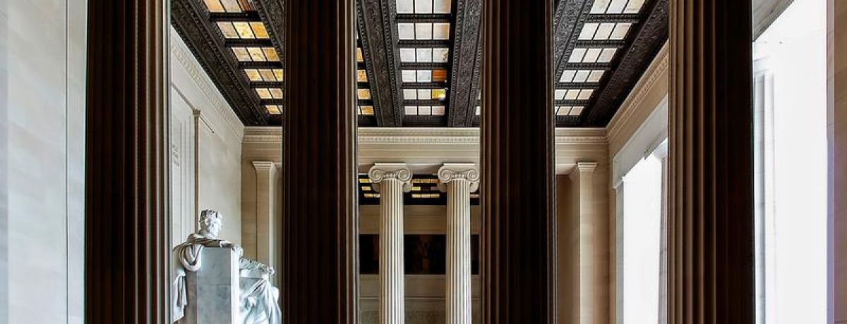 4 pillars of a building with people around