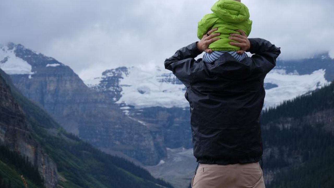 baby on shoulders looking at mountain