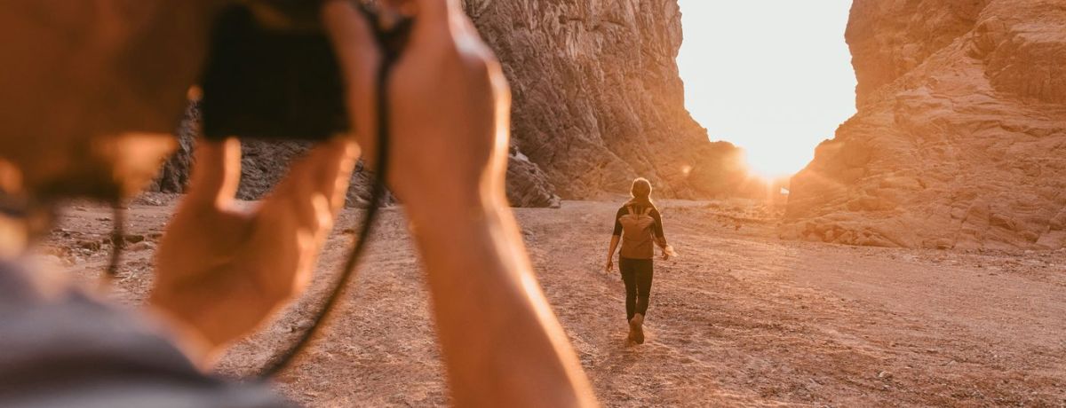 photographer taking a sunset photo with something walking out in the distance