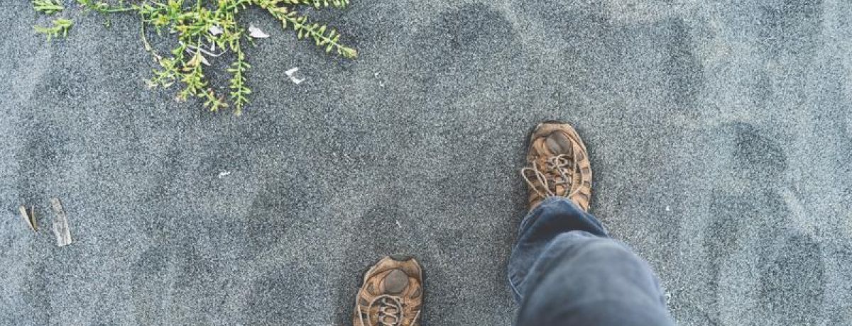 Steps onto sand, feet view