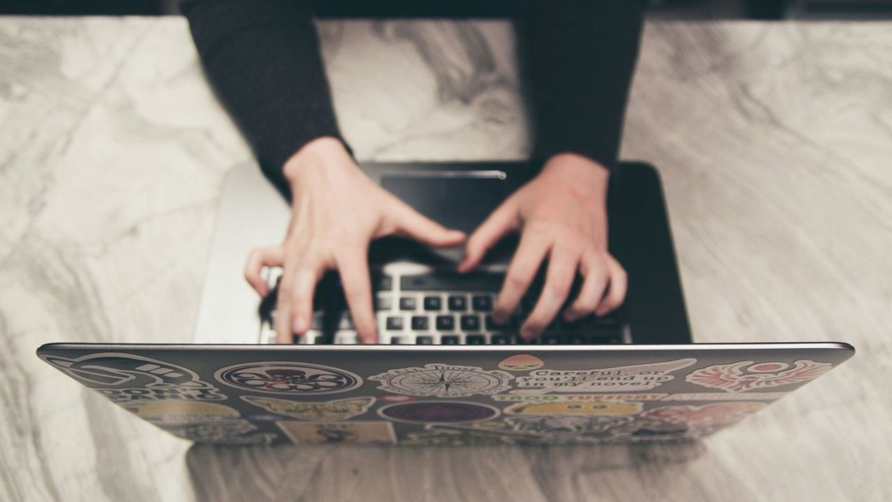 woman typing on a computer on a desk indoors