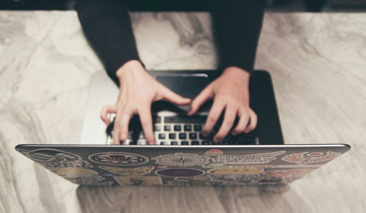woman typing on a computer on a desk indoors