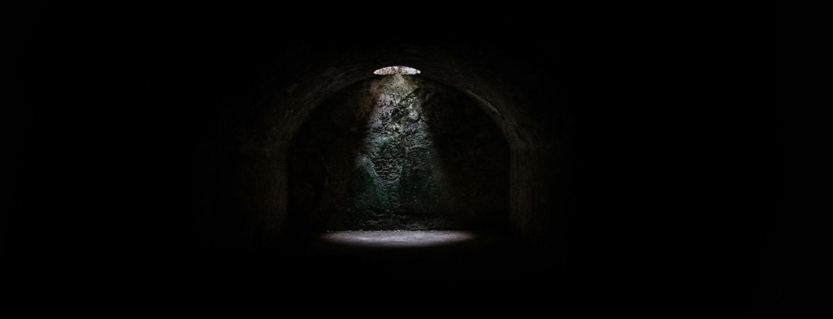 a dark dungeon with a light shining
