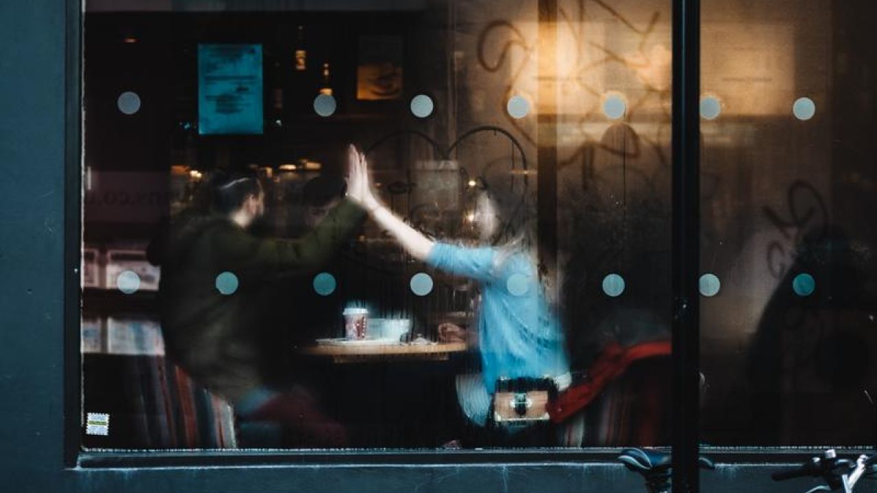 two people high fiving inside a coffee shop