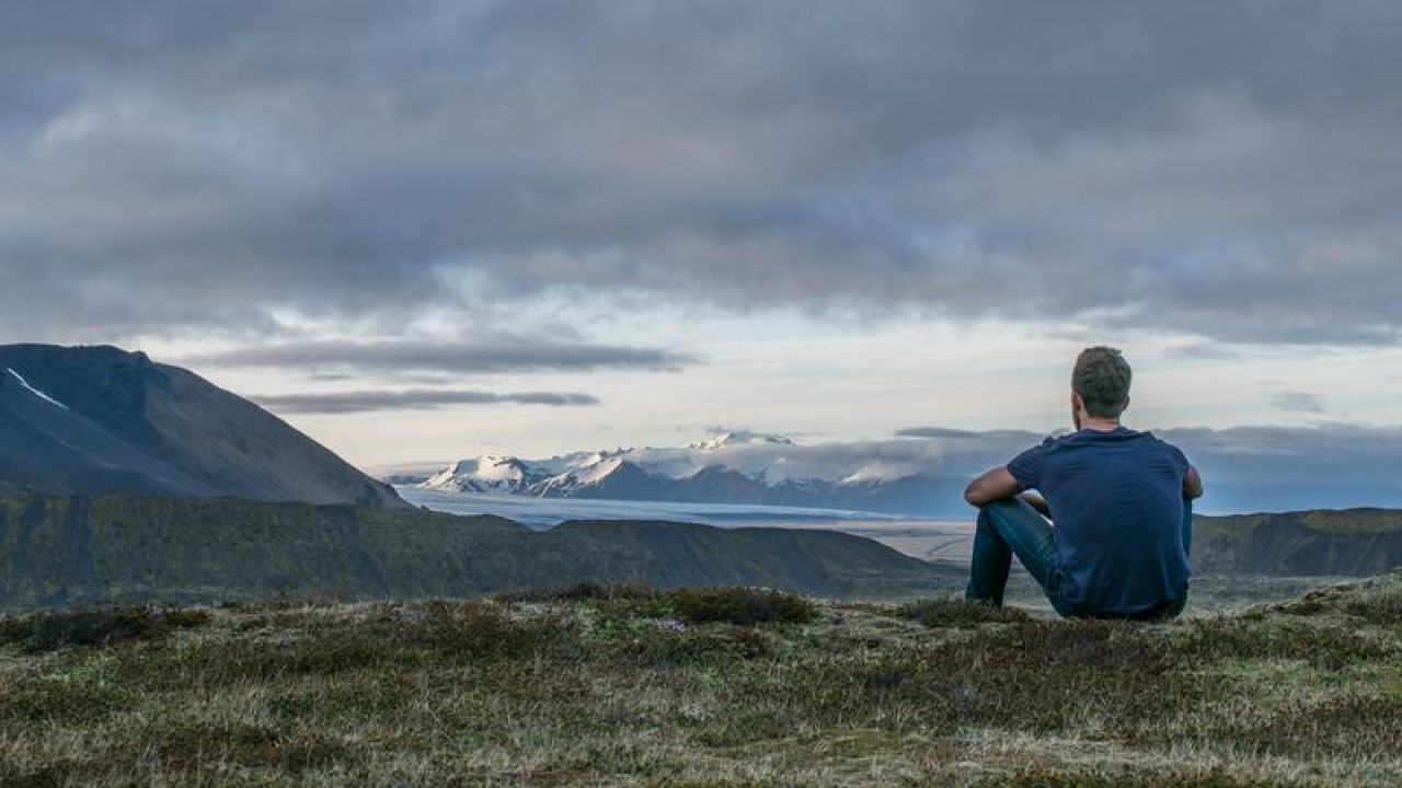 Man looking out to horizon mountains