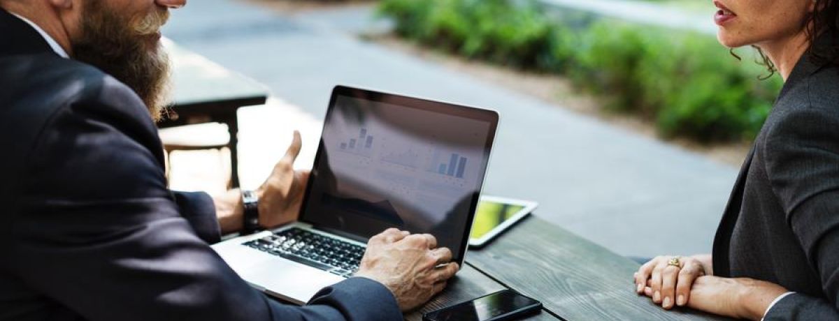 A Man & Woman Talking With A Computer