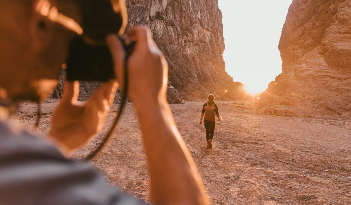 photographer taking a sunset photo with something walking out in the distance