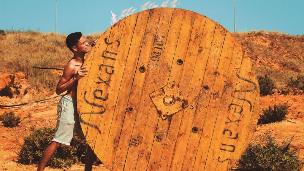 boy pushing large round object