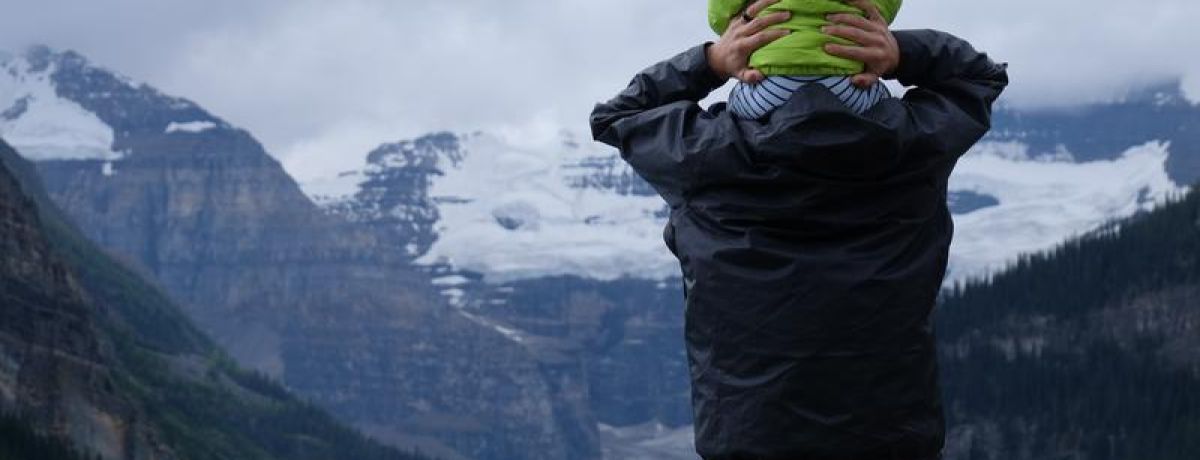 baby on shoulders looking at mountain
