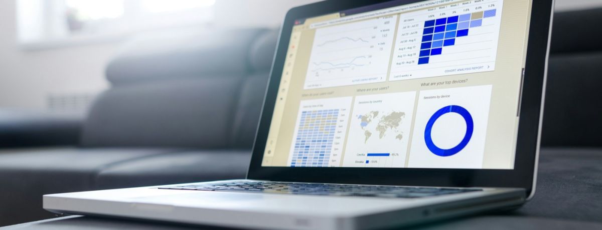 laptop computer on couch, in living room, with reporting on it