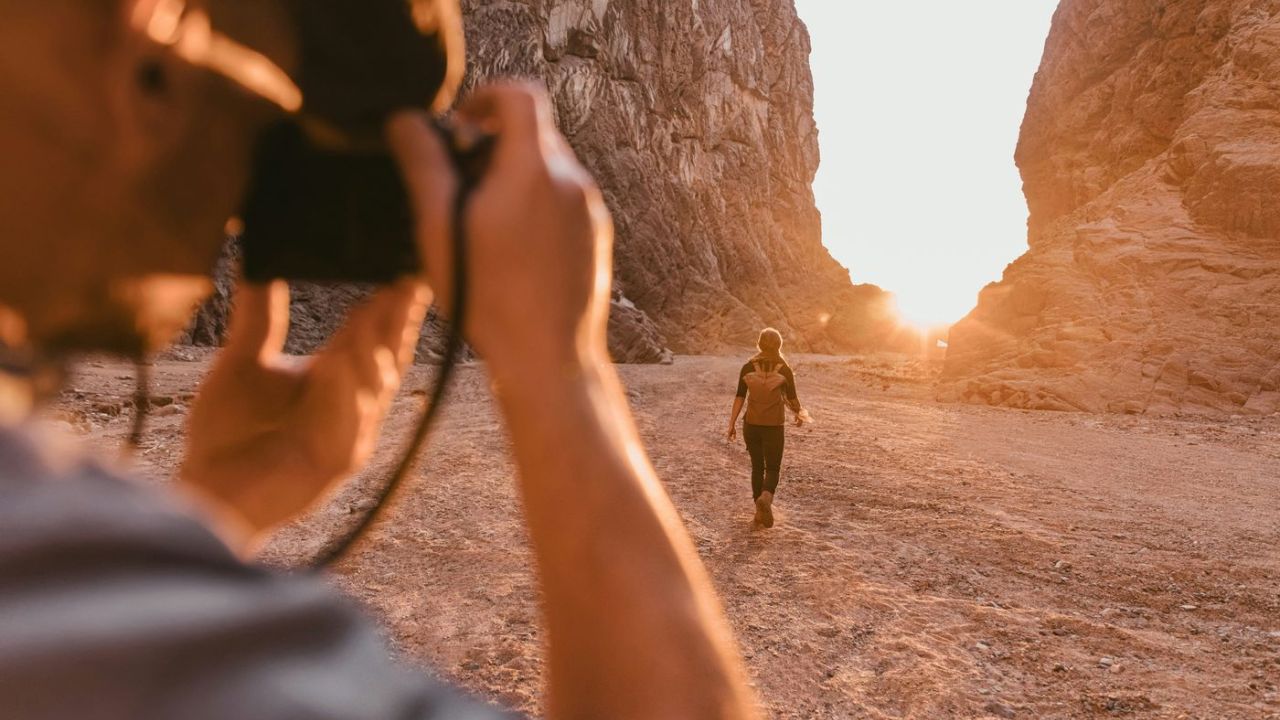photographer taking a sunset photo with something walking out in the distance