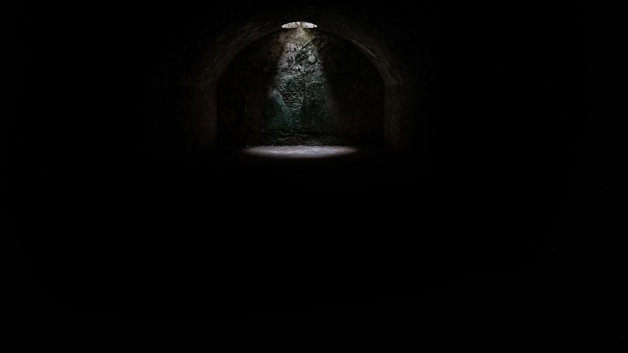 a dark dungeon with a light shining