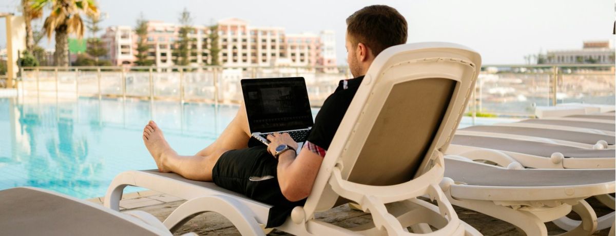 man at the pool on his laptop