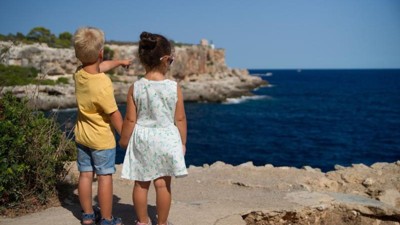 boy leading a girl, pointing out to the horizon