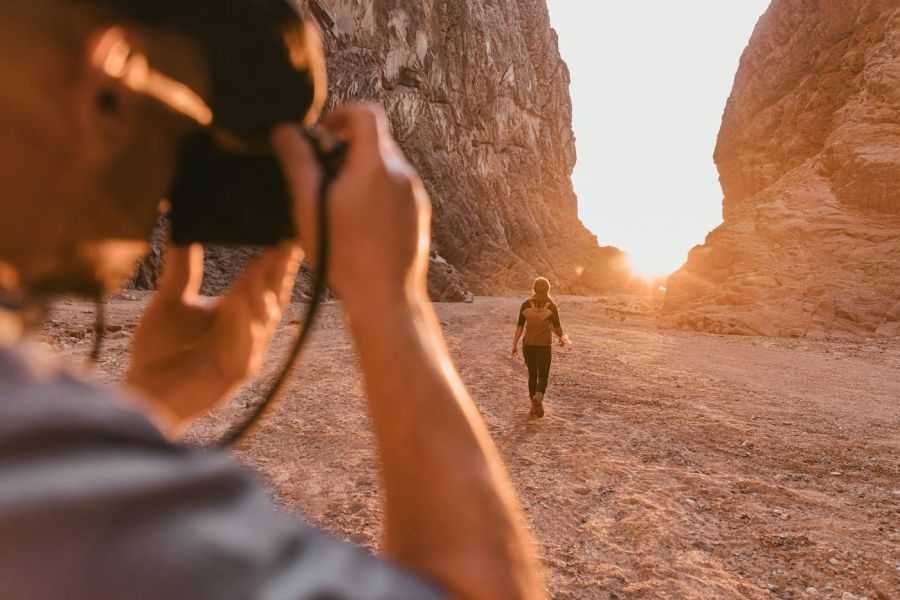 photographer taking a sunset photo with something walking out in the distance