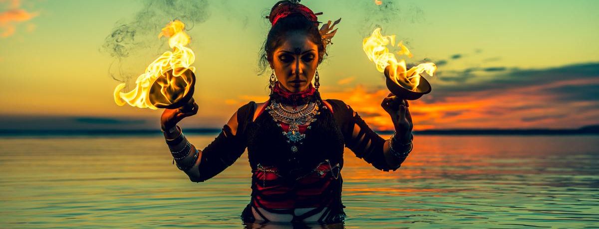 woman wiht fire cups in the water, outdoors