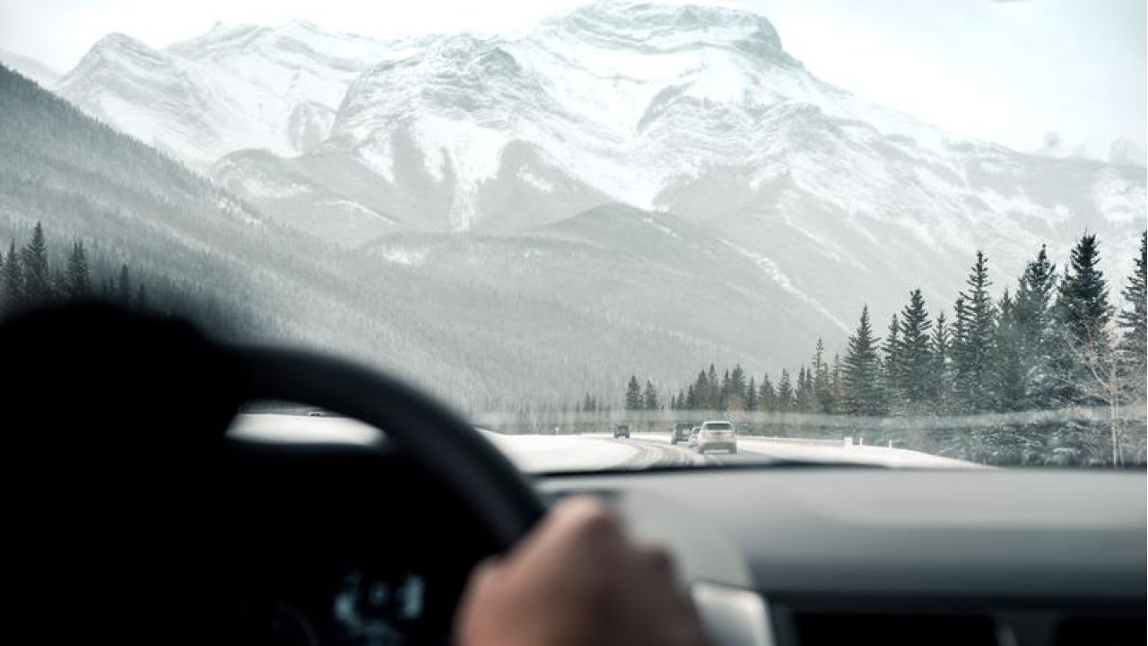 Driving in car toward winter mountain