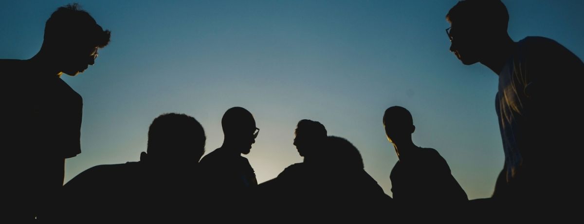 a group of men, outdoors at night