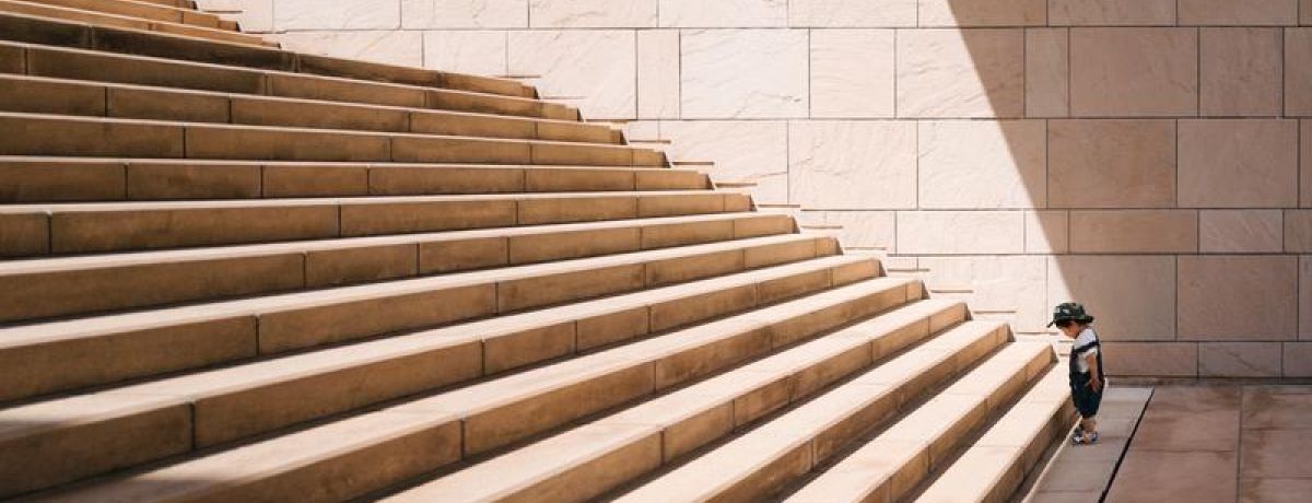 kid looking up stairs about to start climbing