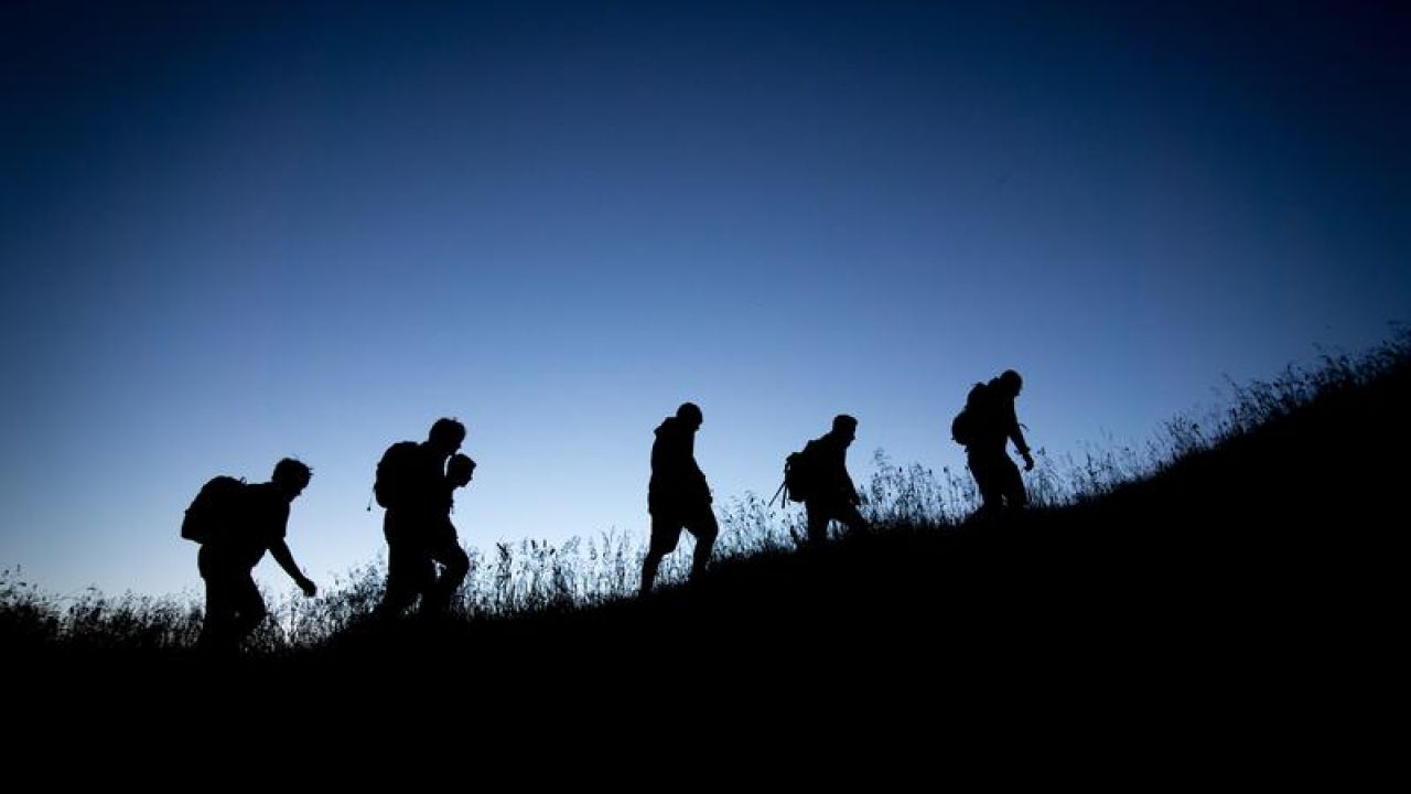 Group of people hiking up hill in the dark
