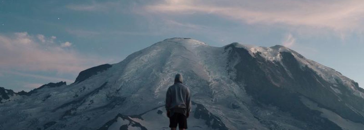 man looking up at mountain