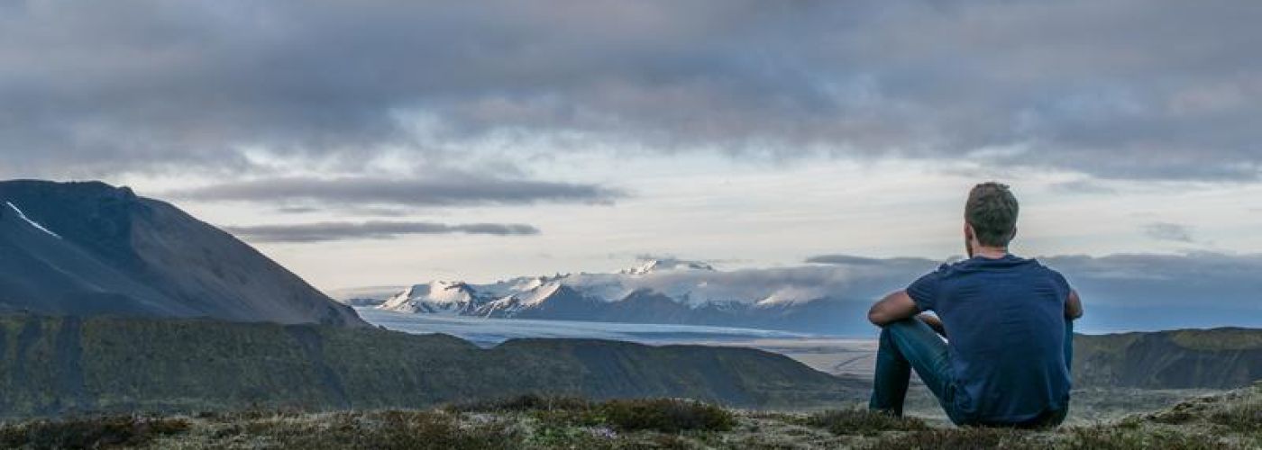 Man looking out to horizon mountains