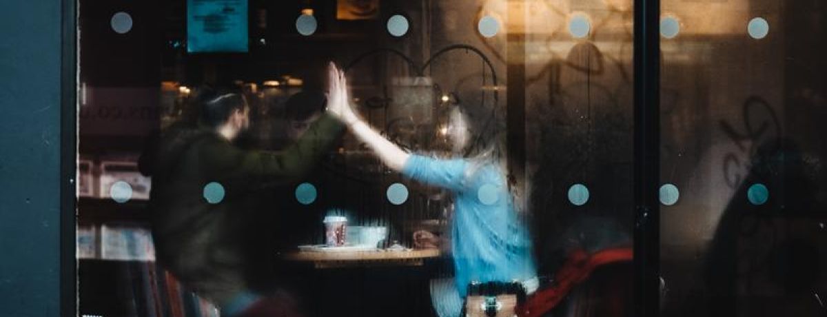 two people high fiving inside a coffee shop